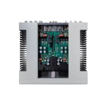 Internal view of a gray industrial power amplifier with exposed green circuit boards, capacitors, and wiring between two modules.