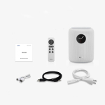 White Wiim wireless speaker with a black circular display, shown with a remote, quick guide, and USB, auxiliary, and power cables nearby