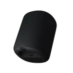 Black fabric-covered cylindrical smart speaker, shown from the bottom/back with visible ports (Ethernet and power) on the base panel.