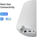 White speaker close-up showing connectivity labels (WiFi 6E, Bluetooth 5.3) and a textured mesh surface with visible input ports on the bottom edge.