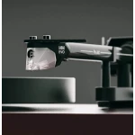 Close-up of a black mechanical clamp labeled MM EVO holding a clear plastic piece.