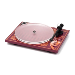 Turntable with a decorative purple base featuring a stylized face artwork and a pink platter cover on top.