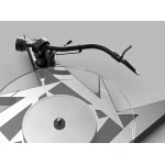 Close-up of a turntable's tonearm and stylus over a vinyl record with gray geometric patterns.