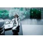 Close-up of a high-end turntable tonearm and cartridge on a glossy black platter.