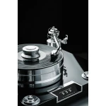 Close-up of a chrome turntable with a spinning vinyl record and metal tonearm against a black background, highlighting the high-end setup.