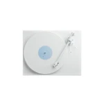 White minimalist turntable with a large circular platter and a pale blue label; tonearm rests to the right on a white surface.