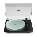 Turntable with the clear lid raised, a black base, and a pale translucent vinyl spinning on the platter with the tonearm on the right