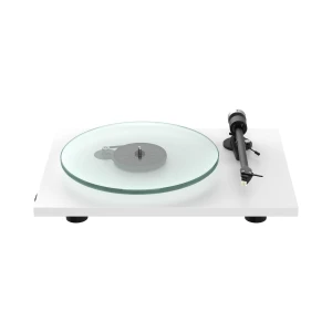 Turntable with a translucent glass platter on a white base and a right-side tonearm ready to play records, photographed from a low angle.