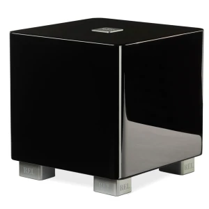 Glossy black subwoofer on silver feet labeled REL, with a small chrome badge on top edge.