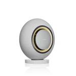 Spherical gray Marantz speaker with textured fabric, gold-rimmed circular opening, resting on a white marble pedestal.