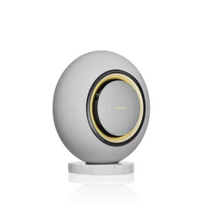 Spherical gray Marantz speaker with textured fabric, gold-rimmed circular opening, resting on a white marble pedestal.