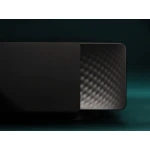 Close-up of a black device edge: matte left panel and rounded right corner with a carbon-fiber textured surface.