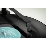 Close-up of a vinyl record on a turntable being brushed by a cleaning brush to remove dust and static.