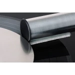 Close-up of a vinyl record being cleaned by a cylindrical roller brush with white bristles on a black LP surface.
