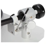 Close-up of a microscope focusing mechanism with a large black dial and silver adjustment knobs on a white frame.